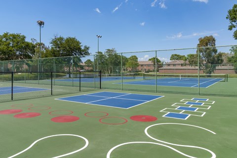 a tennis court with logos on it on a sunny day