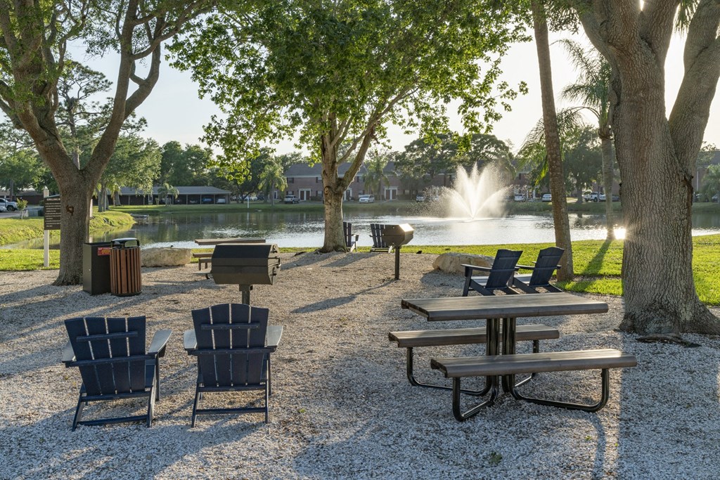 a park with tables and chairs next to a fountain