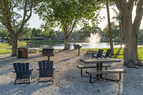 a park with tables and chairs next to a fountain