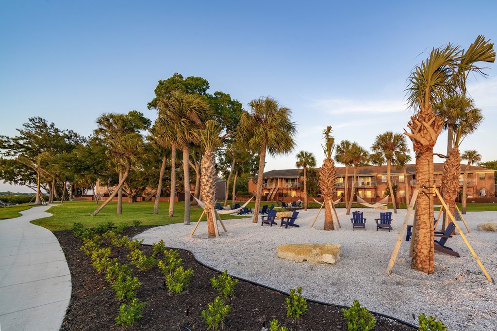 a playground with palm trees and a building in the background