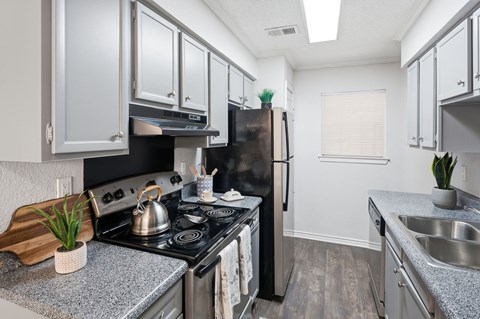 A kitchen with a black stove top oven and a black refrigerator.