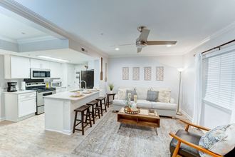 Living room and kitchen area with white walls and tiles flooring and a ceiling fan at Juniper Springs Apartments, Austin, TX 78731