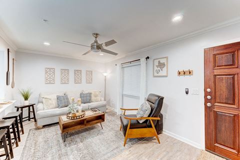 Living room with white walls and a ceiling fan at Juniper Springs Apartments, Austin, TX 78731