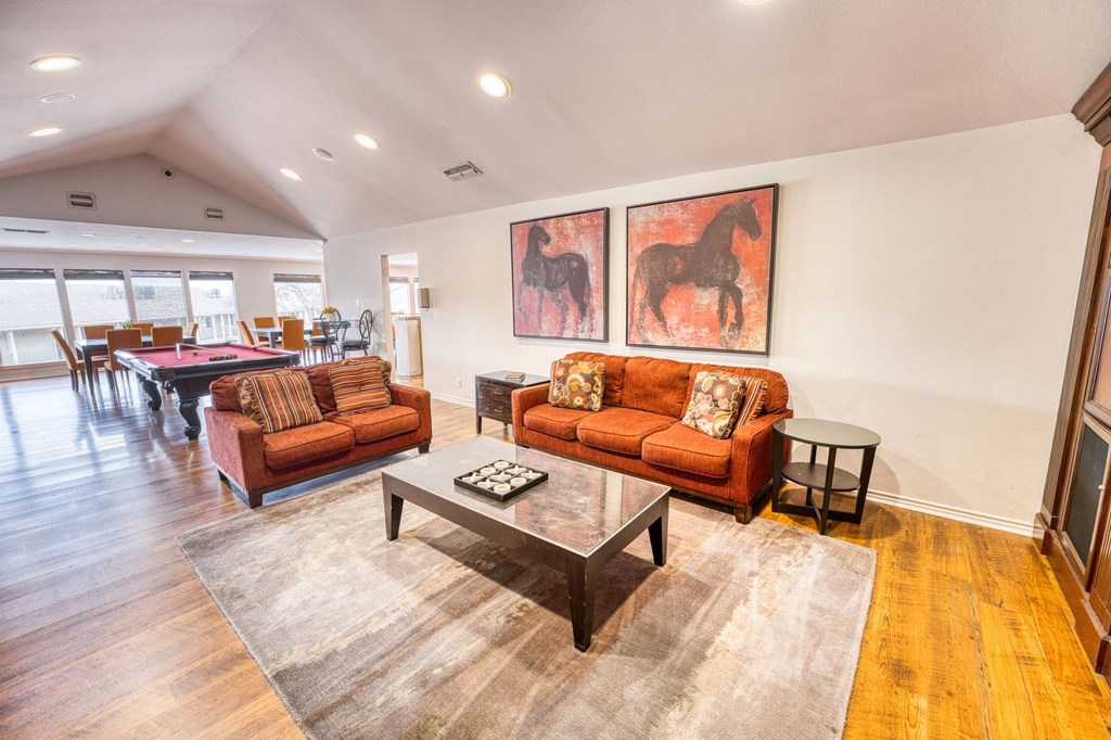 a living room with couches and a table with a pool table
