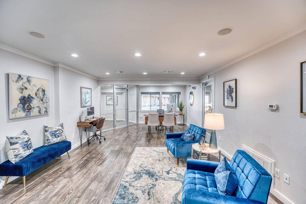 a living room with blue couches and a dining room with a table and chairs