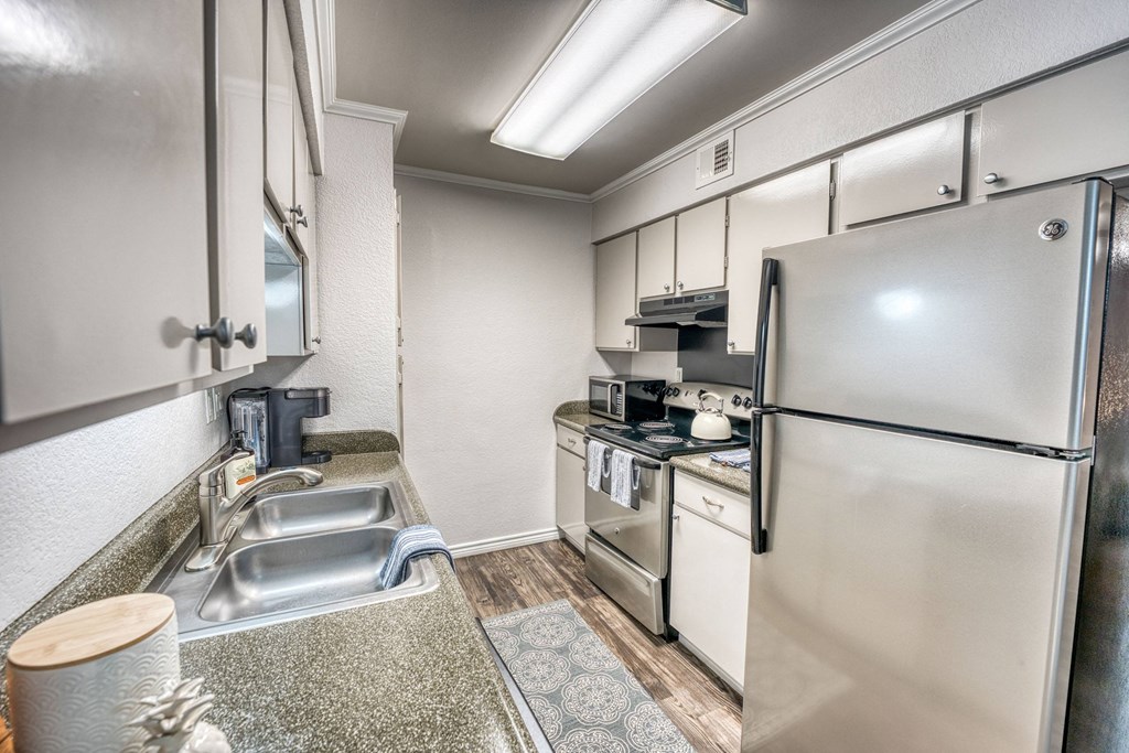 the kitchen has stainless steel appliances and white cabinets