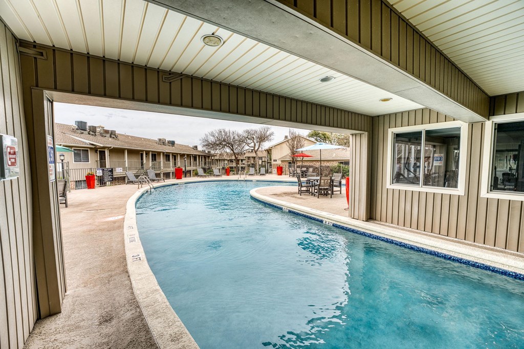 the pool is open to the outside of a house with a large window
