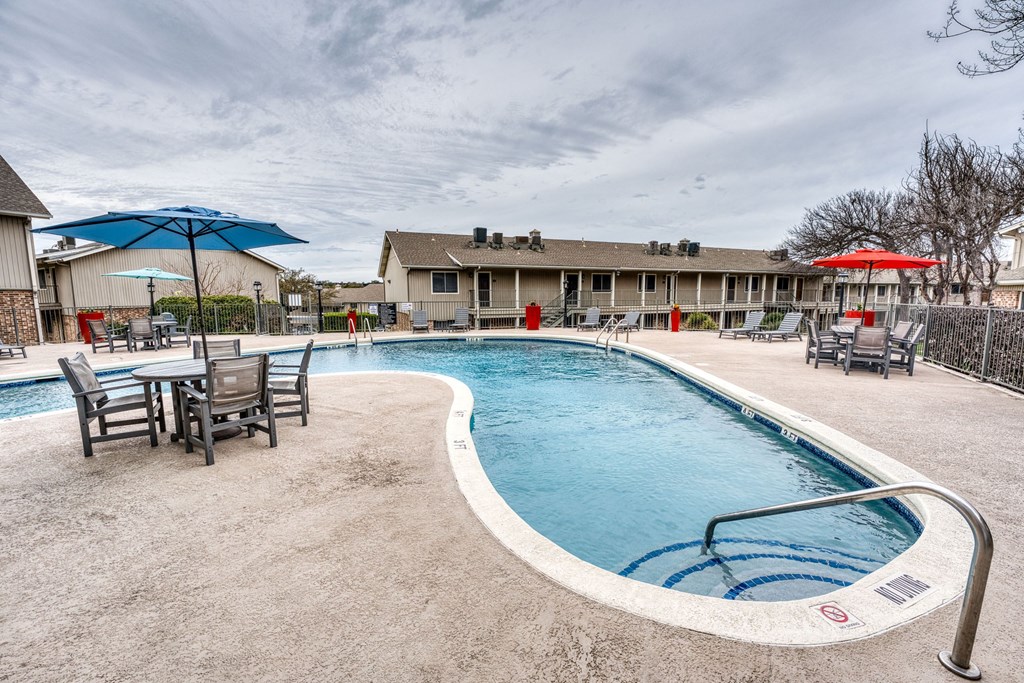 our apartments have a resort style pool with chairs and umbrellas