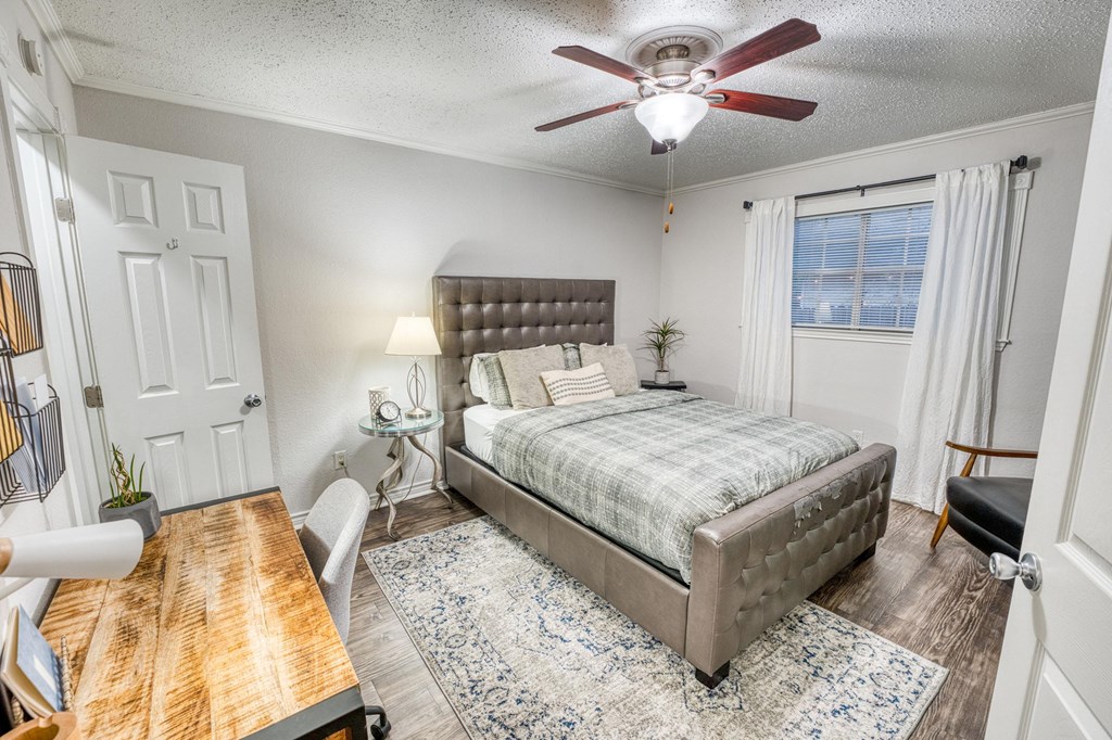 a bedroom with a bed and a ceiling fan
