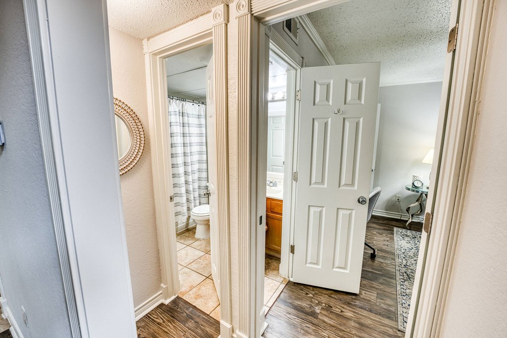 an open door leading into a bathroom with a shower and a toilet