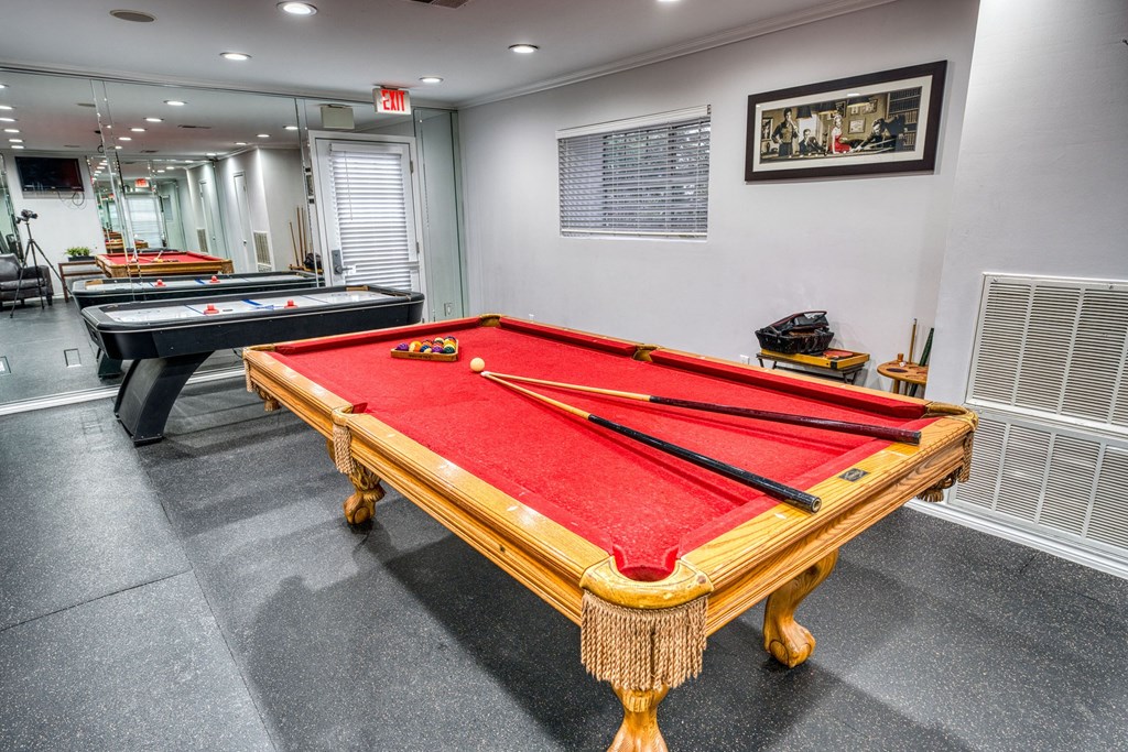 a game room with two pool tables and two billiards