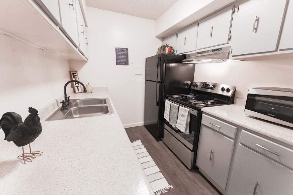 a kitchen with white cabi nets and a black stove top oven  at Cantera Apartments, El Paso TX 79935