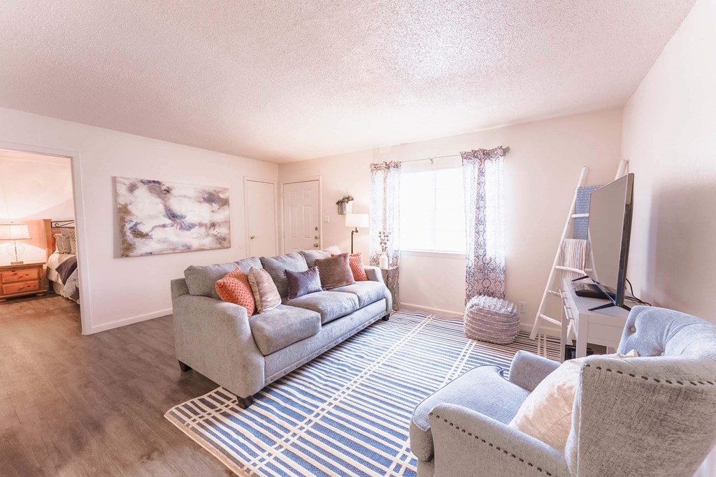 a living room with a couch and two chairs  at Cantera Apartments, El Paso TX 79935