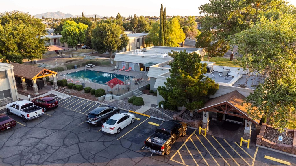 a view of a parking lot with a pool and a building in the background  at Cantera Apartments, El Paso TX 79935