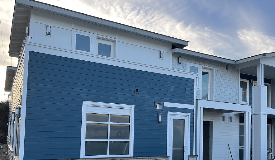 a blue house with a cloudy sky in the background