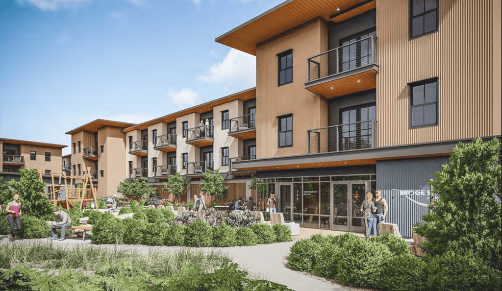 A modern apartment complex with balconies and a garden area in front.