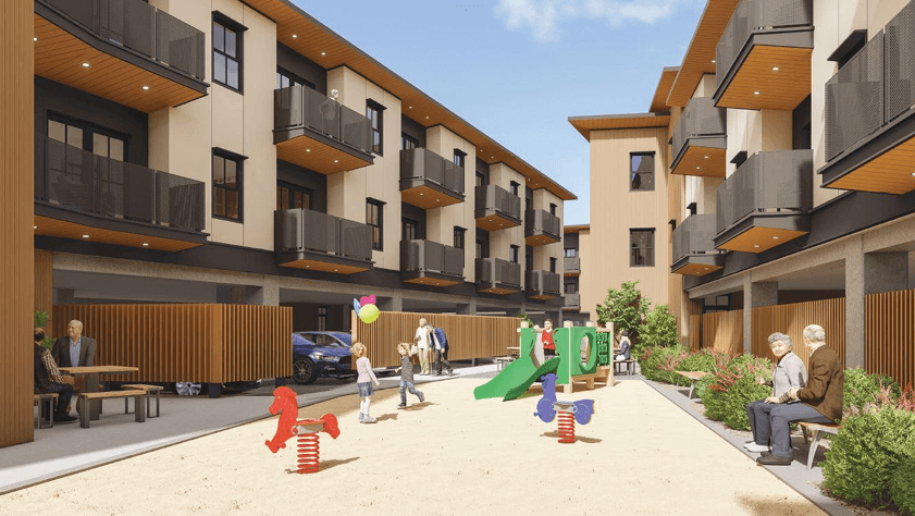 A playground area with a slide and a sandbox is located between two apartment buildings.