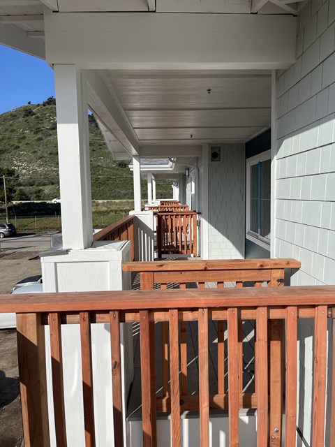 a view of a porch with a wooden railing