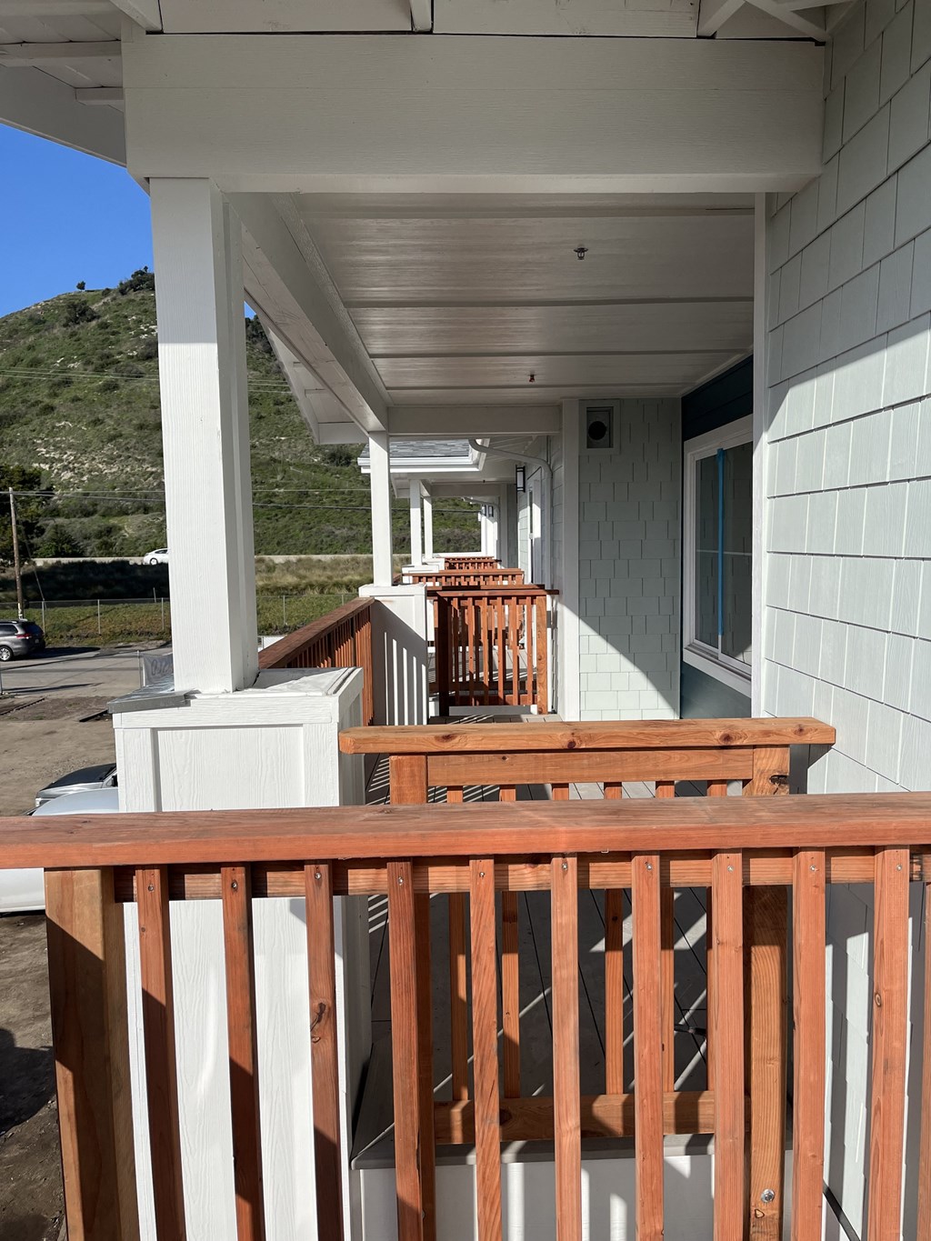 a view of a porch with a wooden railing