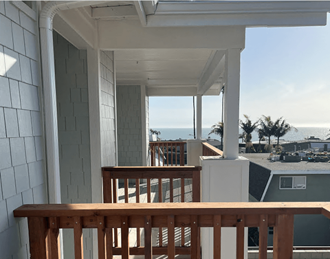 a view of the ocean from the balcony of a beach house