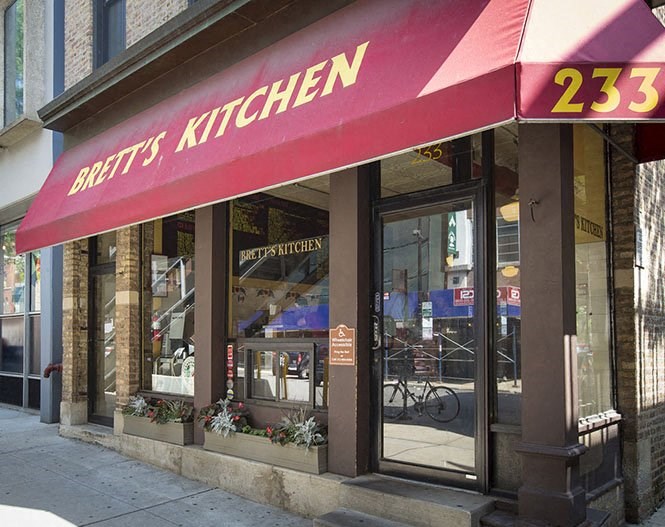 the front of a restaurant with a red awning