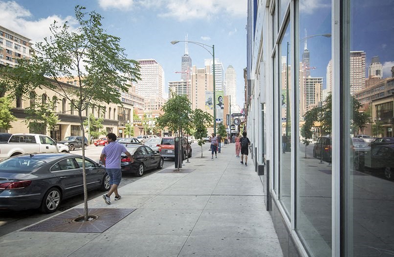 people walking on a sidewalk next to a city street