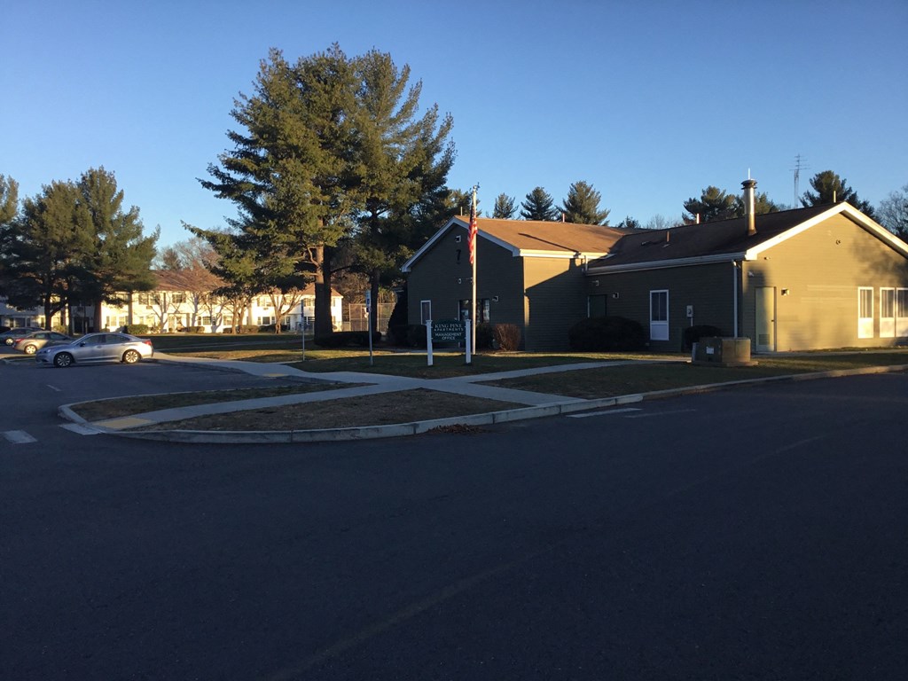 a street corner with a house and a parking lot