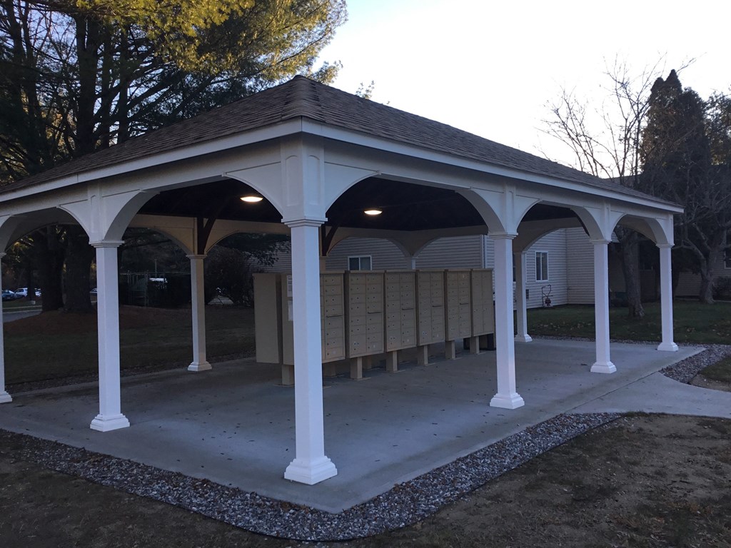 a pavilion with a seating area in front of a house