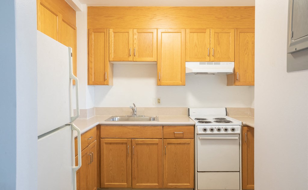 a kitchen with white appliances and wooden cabinets