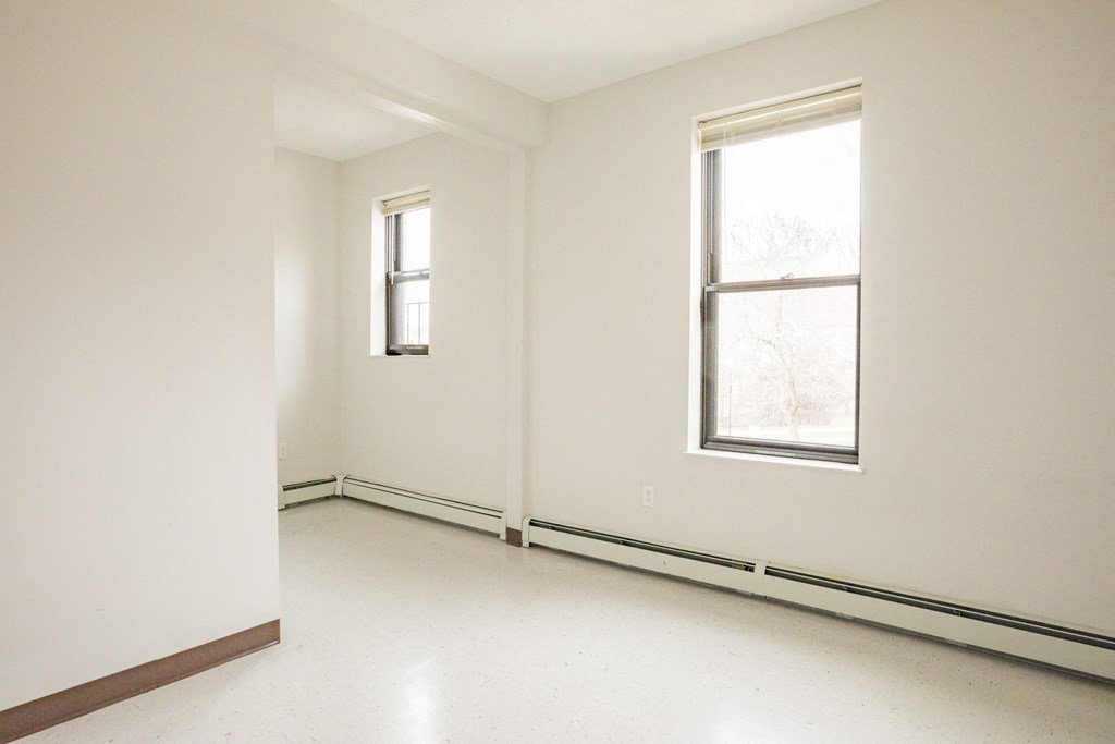 an empty room with two windows in it