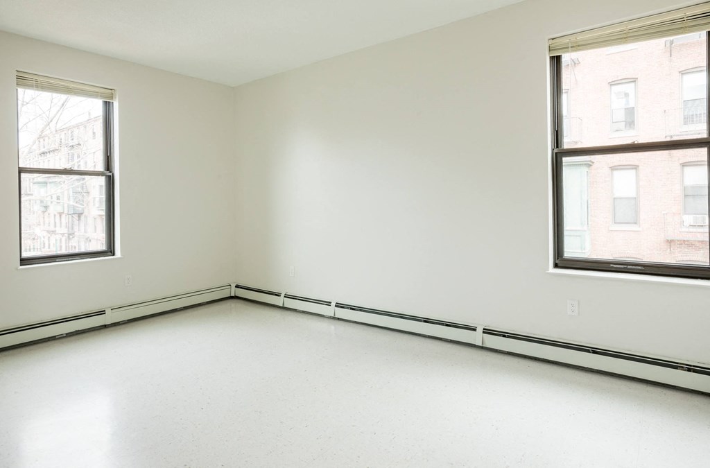an empty room with two windows in it