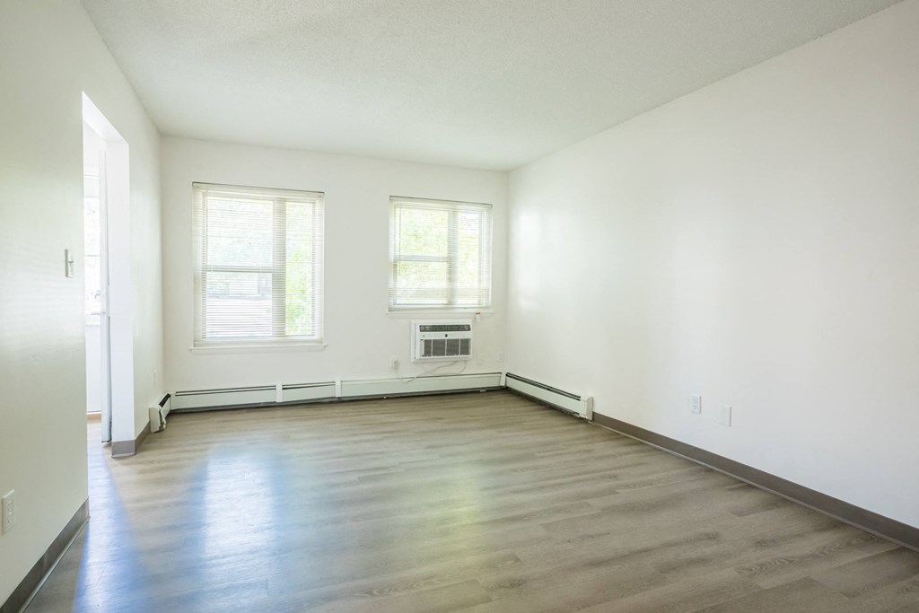 an empty living room with white walls and wood floors