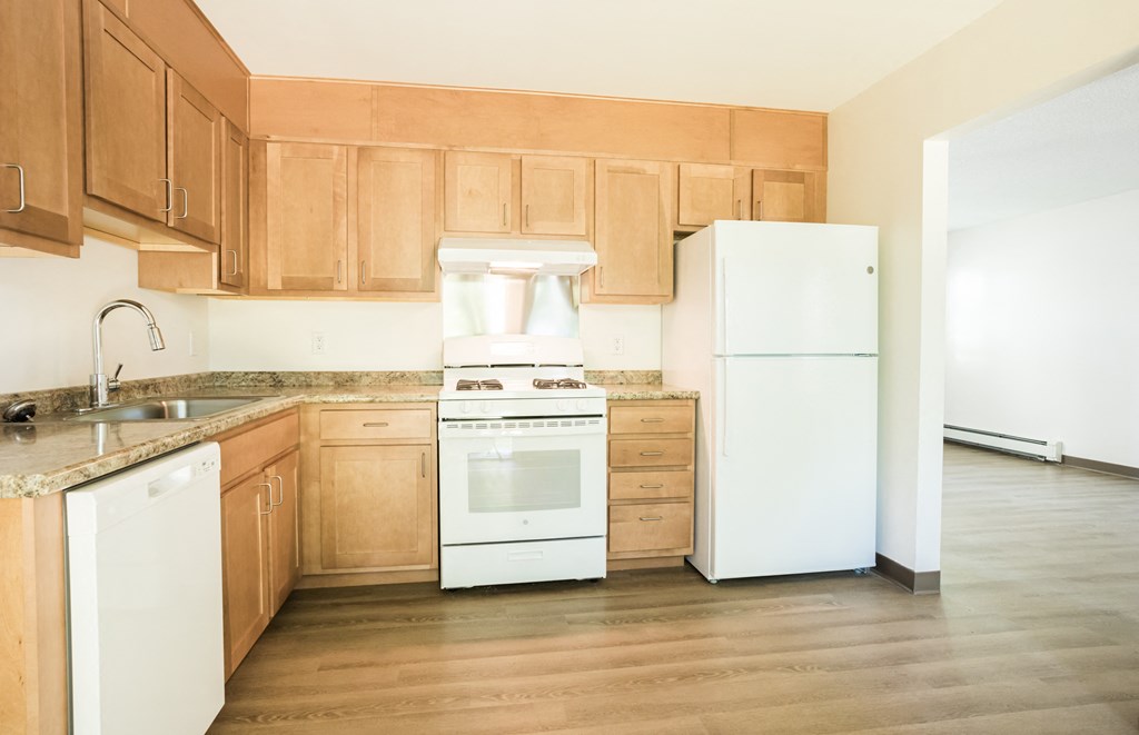 a kitchen with white appliances and wooden cabinets