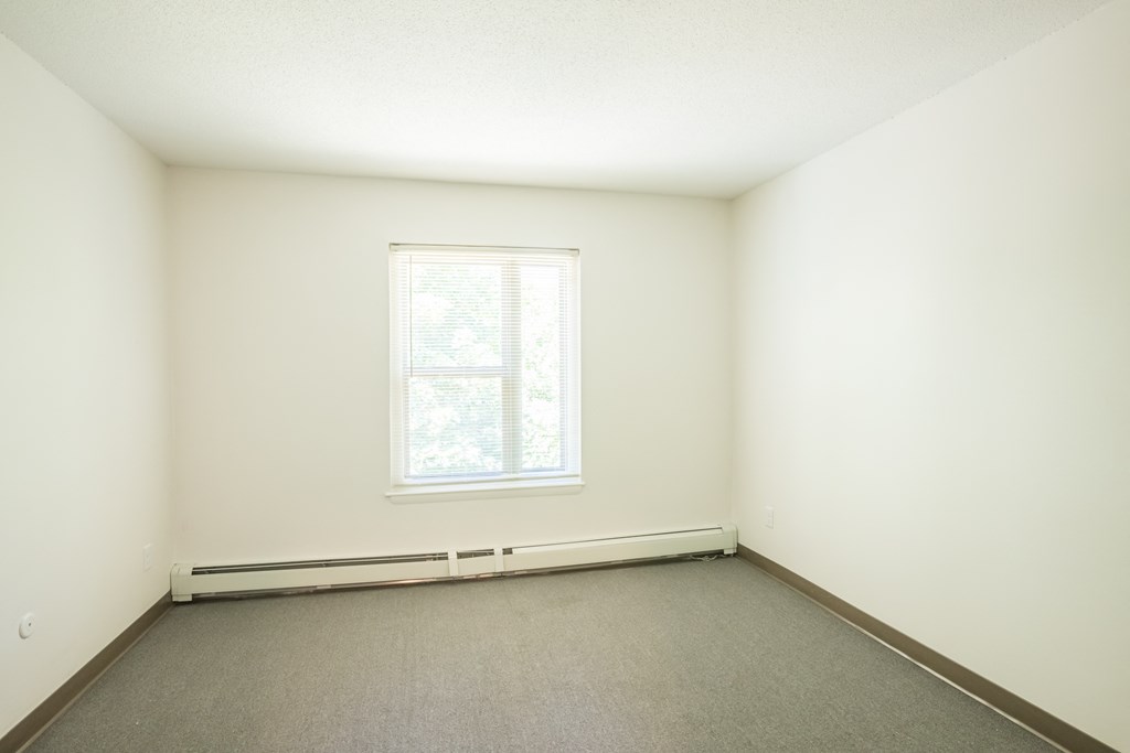 an empty room with white walls and a window