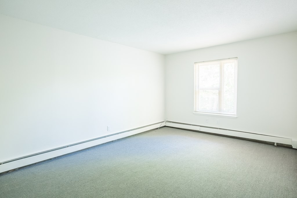 an empty room with white walls and a window