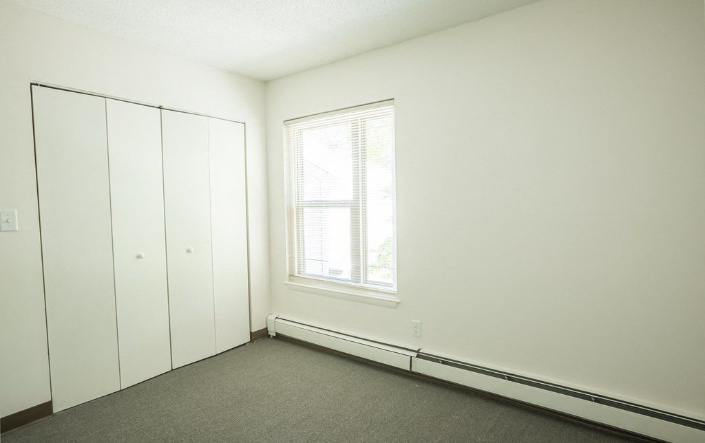 an empty room with white walls and a window