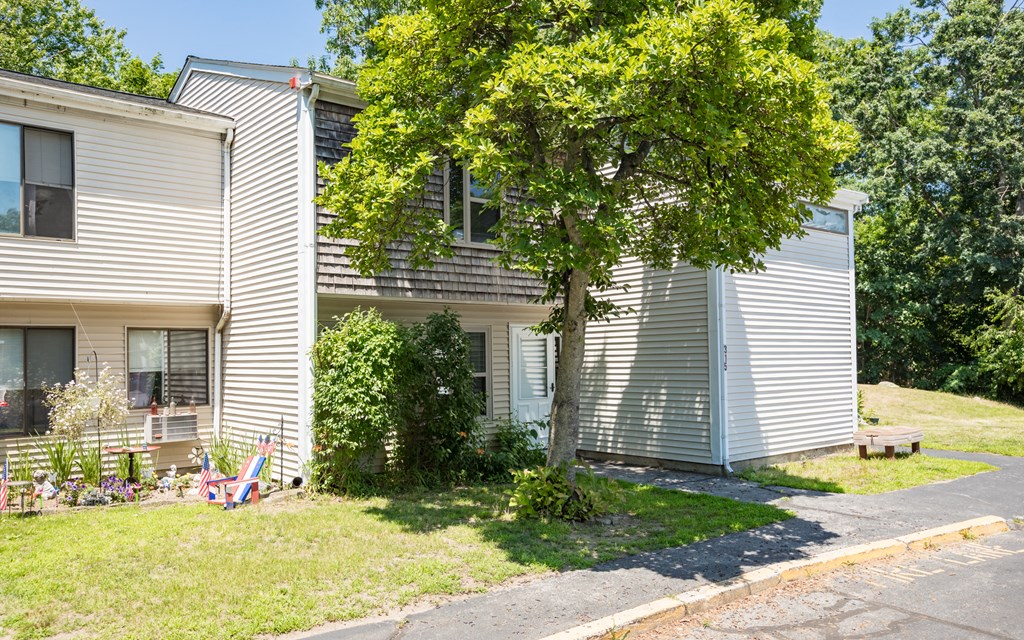 a white house with a tree in front of it