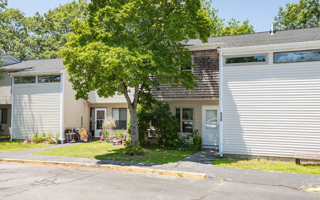 a white house with a tree in front of it