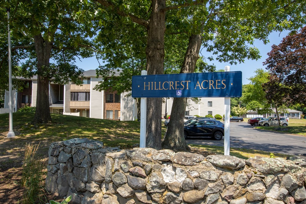 a blue street sign in front of a stone wall
