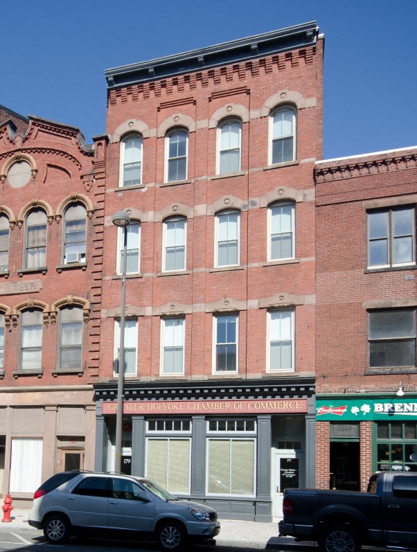 a large brick building with cars parked in front of it