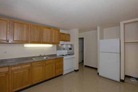A kitchen with wooden cabinets and white appliances.