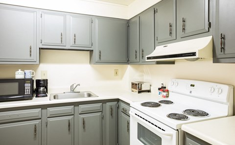 a kitchen with white appliances and gray cabinets