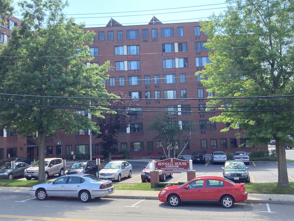 a parking lot with cars in front of a brick building