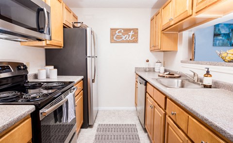 a kitchen with a stove refrigerator and sink