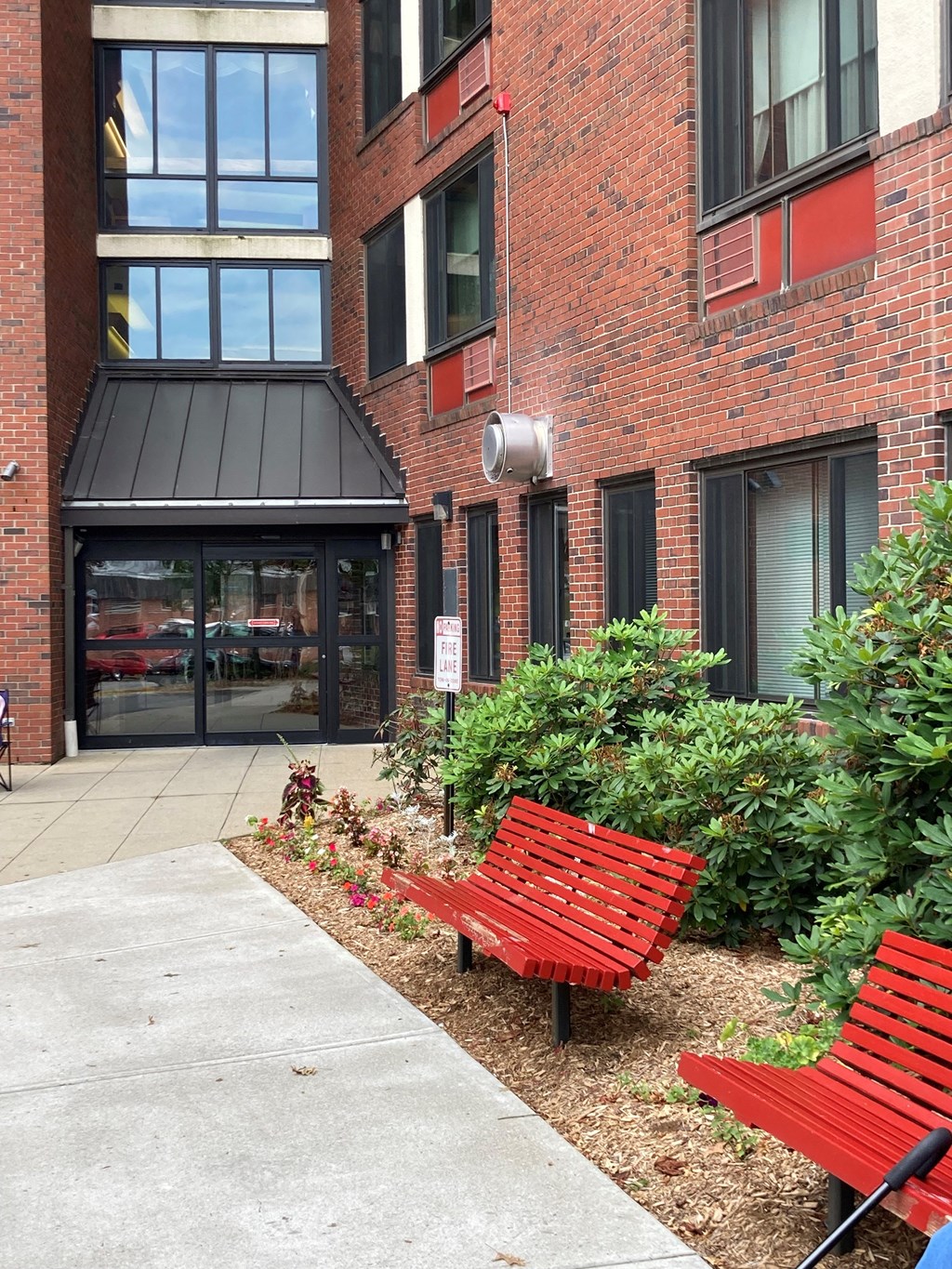 a red bench in front of a brick building