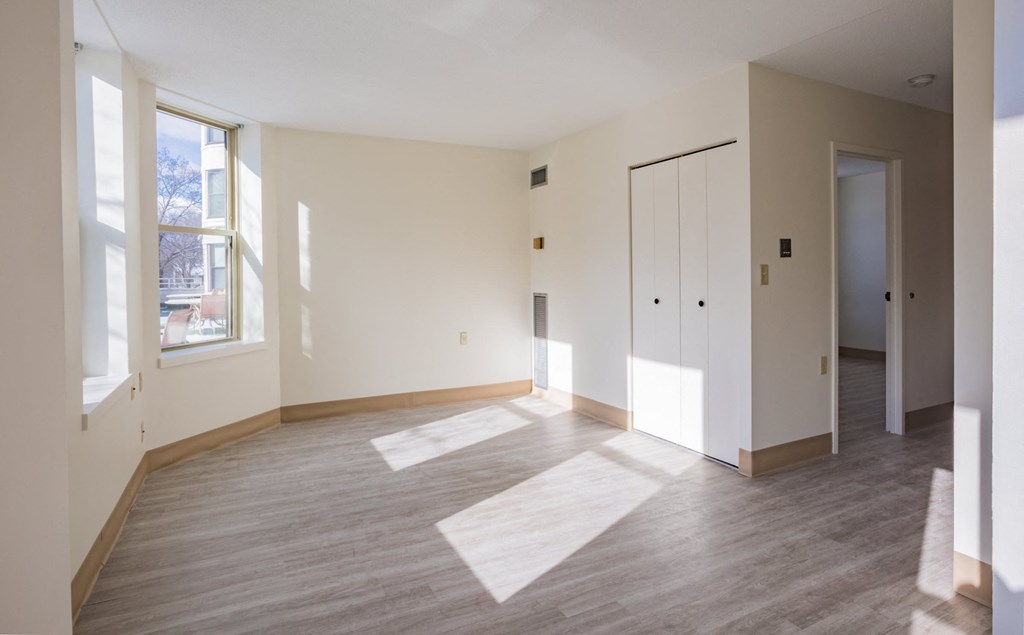 an empty living room with white walls and wood floors