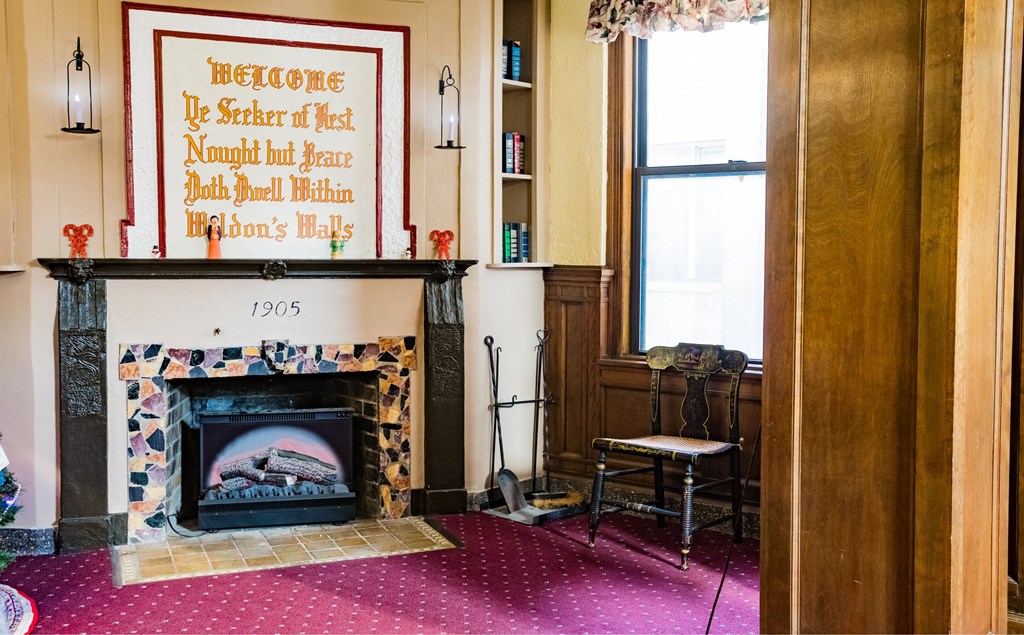 the living room with a fireplace and a poster on the wall