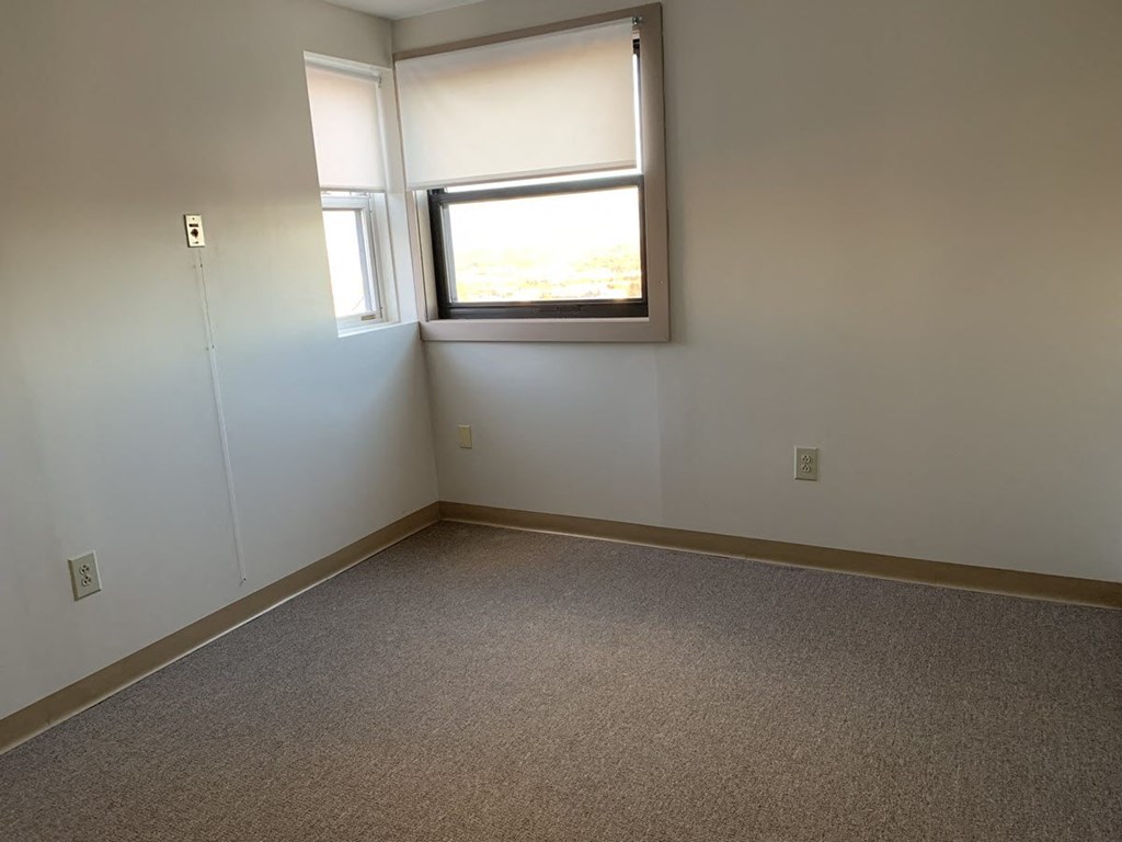 a room with a window and a carpet