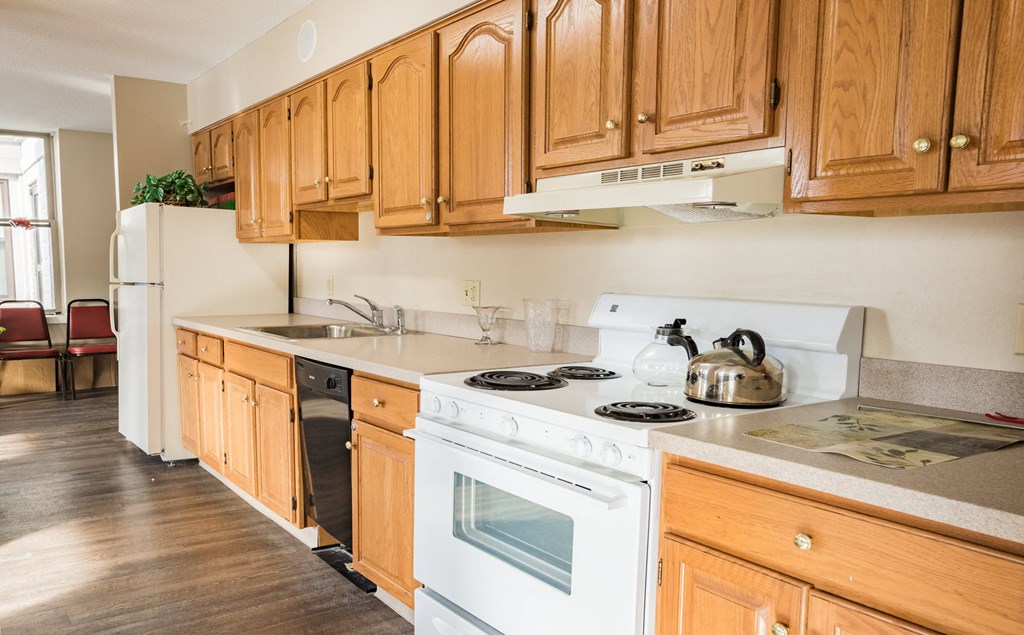 a kitchen with wooden cabinets and a white stove top oven