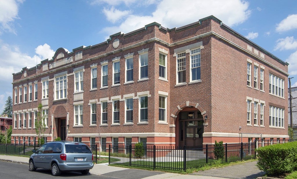 a large brick building with a car parked in front